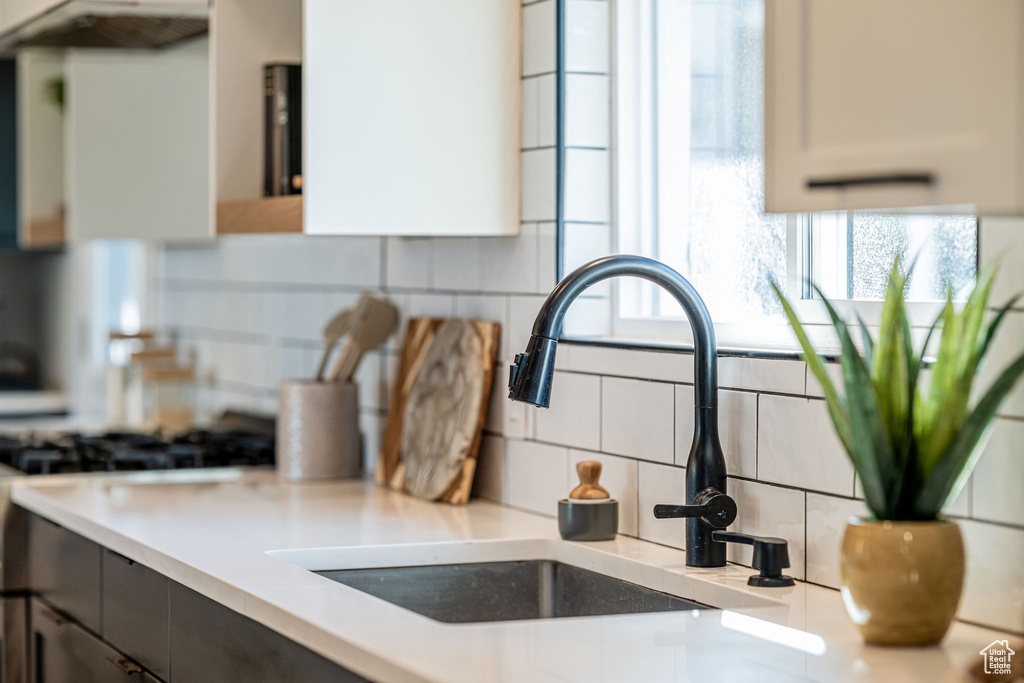 Kitchen view of backsplash, light countertops, and stove