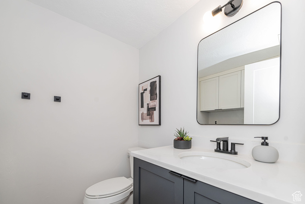Half bathroom with vanity and toilet