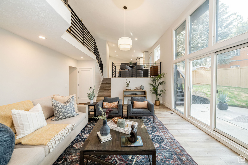 Living room featuring stairway, light wood finished floors, and recessed lighting