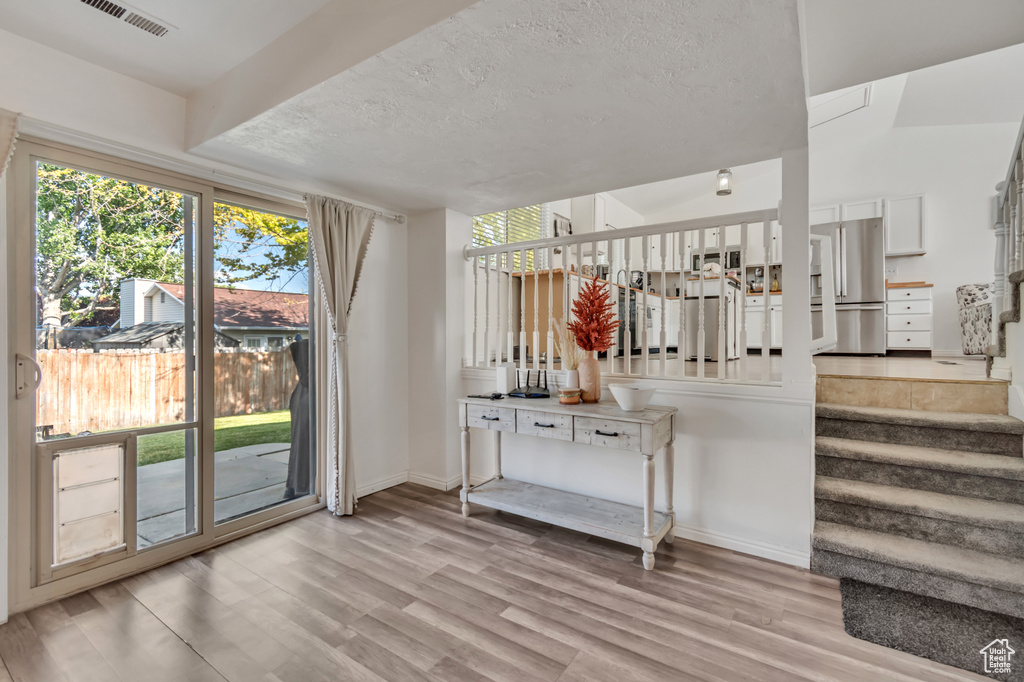 Staircase featuring wood finished floors and a textured ceiling