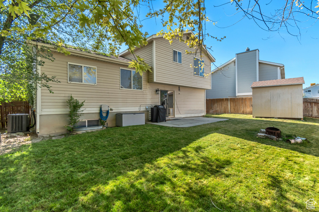 Rear view of property featuring a fenced backyard, a patio area, and a fire pit