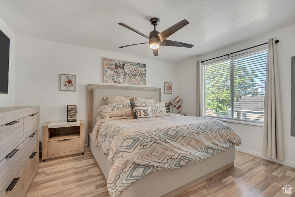 Bedroom with light wood-style floors and a ceiling fan