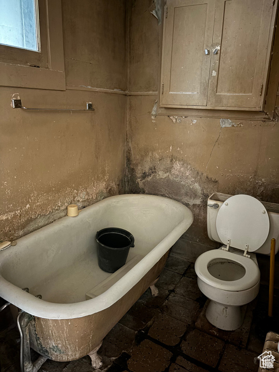 Full bathroom with a soaking tub and toilet