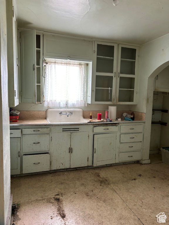 Kitchen with arched walkways, open shelves, and light countertops