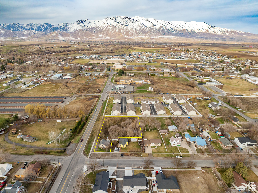 Aerial perspective of suburban area featuring a mountain backdrop and property parcel outlined