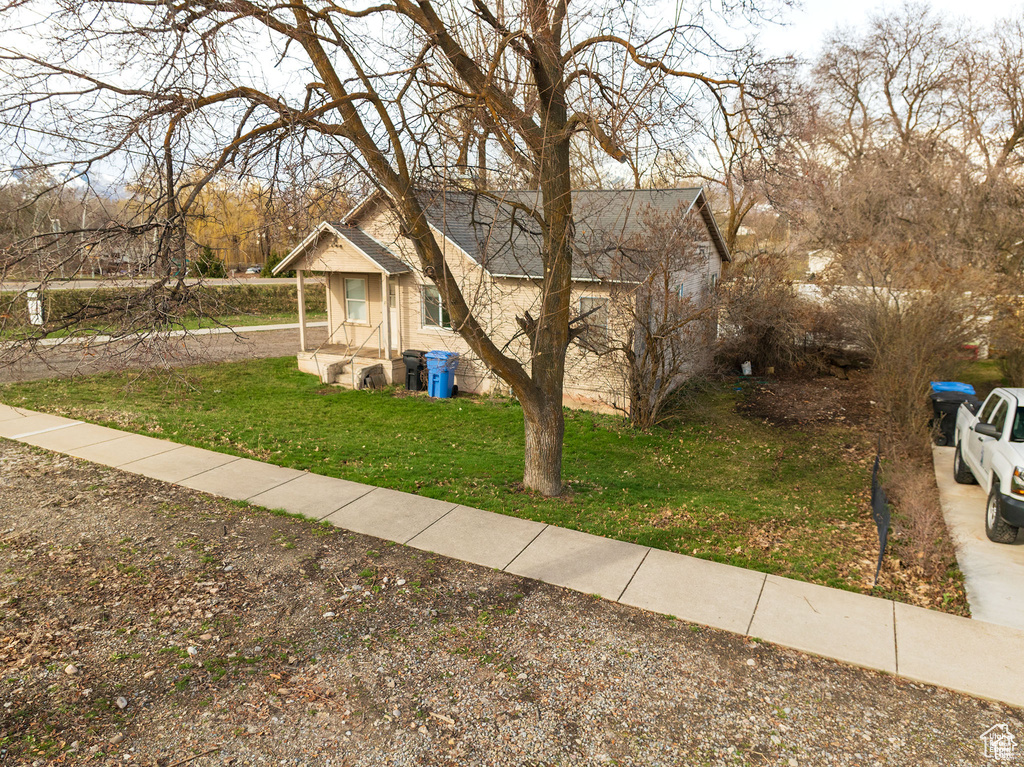 View of front facade with a front yard and roof with shingles