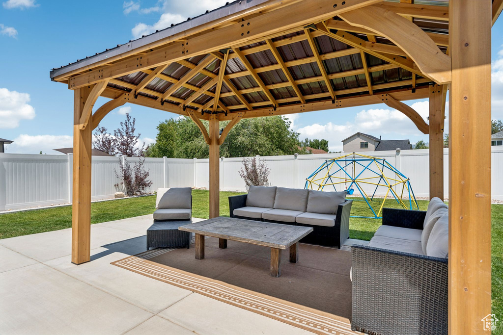 Fenced backyard featuring a patio area, an outdoor living space, and a gazebo