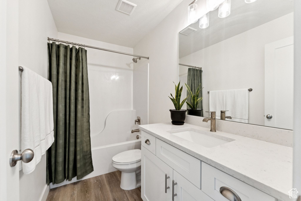 Full bathroom featuring vanity, wood finished floors, and shower / tub combo