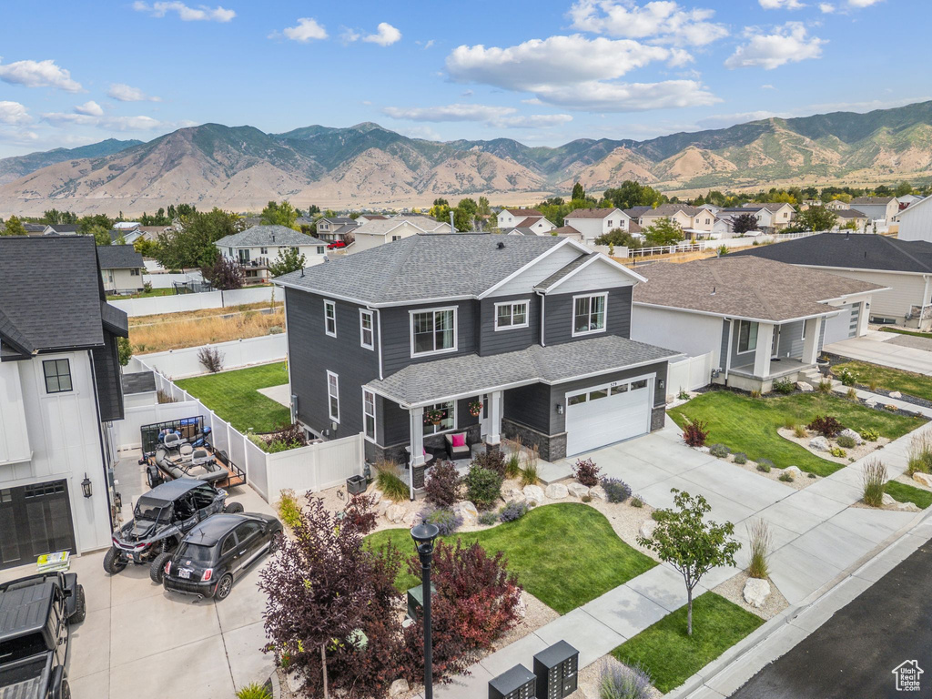 Traditional home featuring concrete driveway, a residential view, and a mountain view