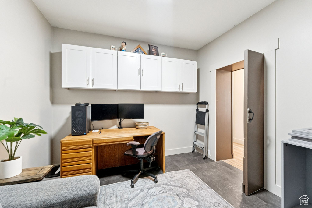 Home office with dark wood finished floors and baseboards