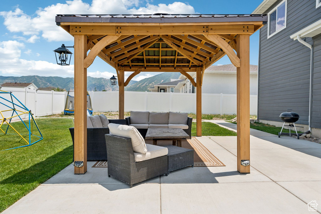 Fenced backyard with a mountain view, an outdoor hangout area, a gazebo, and a patio area