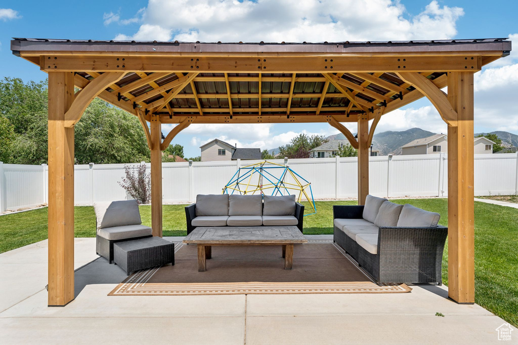 Fenced backyard with a gazebo, outdoor lounge area, and a patio area