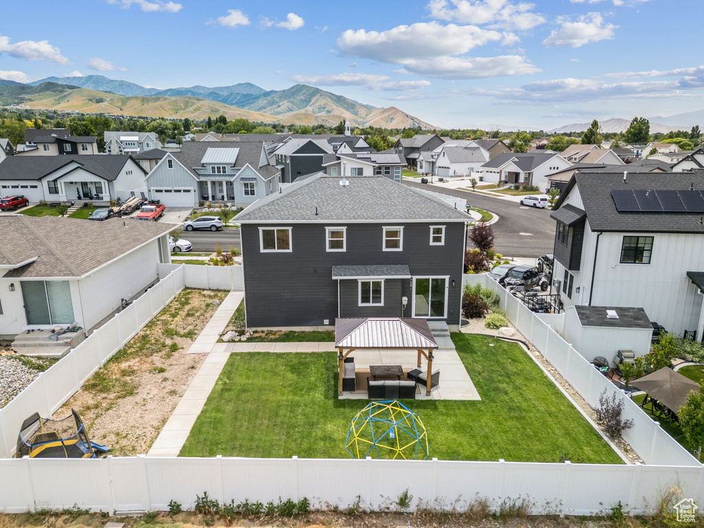 Rear view of house with a residential view, a mountain view, and a fenced backyard