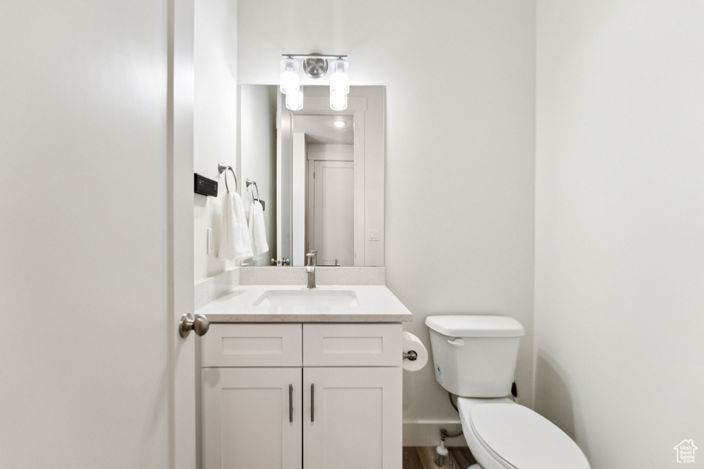 Half bathroom with vanity and wood finished floors