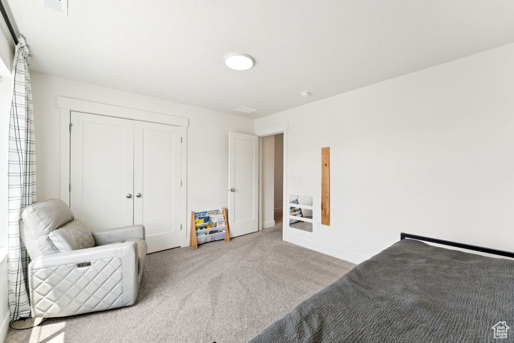 Bedroom featuring carpet flooring and a closet