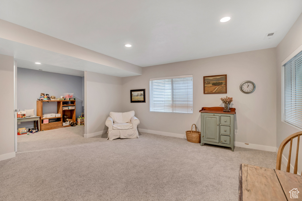 Sitting room with light colored carpet and recessed lighting