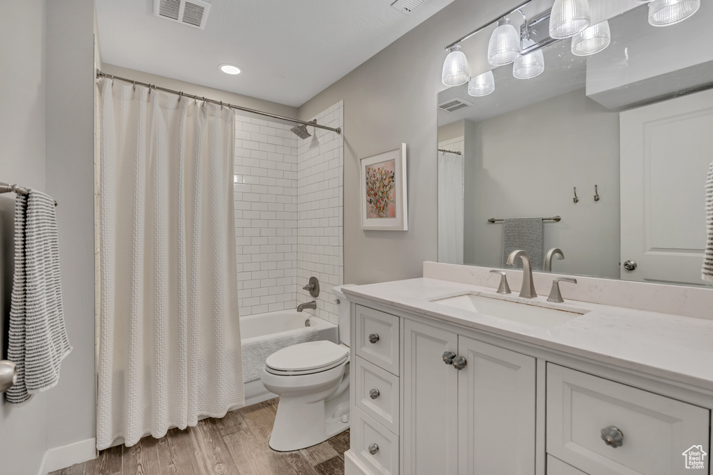 Bathroom with vanity, wood finished floors, and shower / bath combo