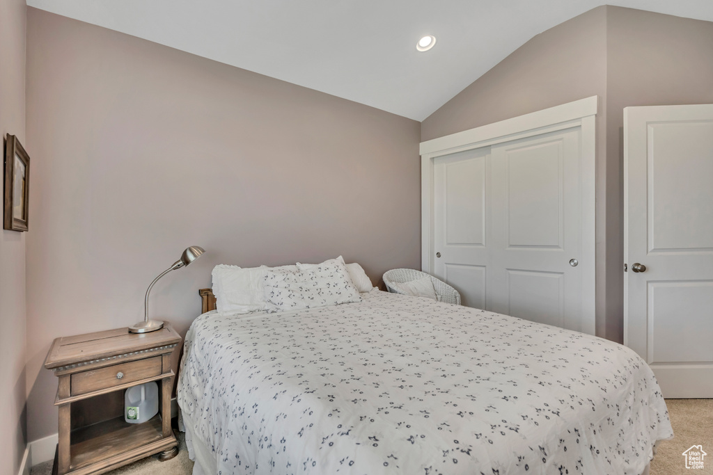 Bedroom featuring lofted ceiling, light colored carpet, recessed lighting, and a closet