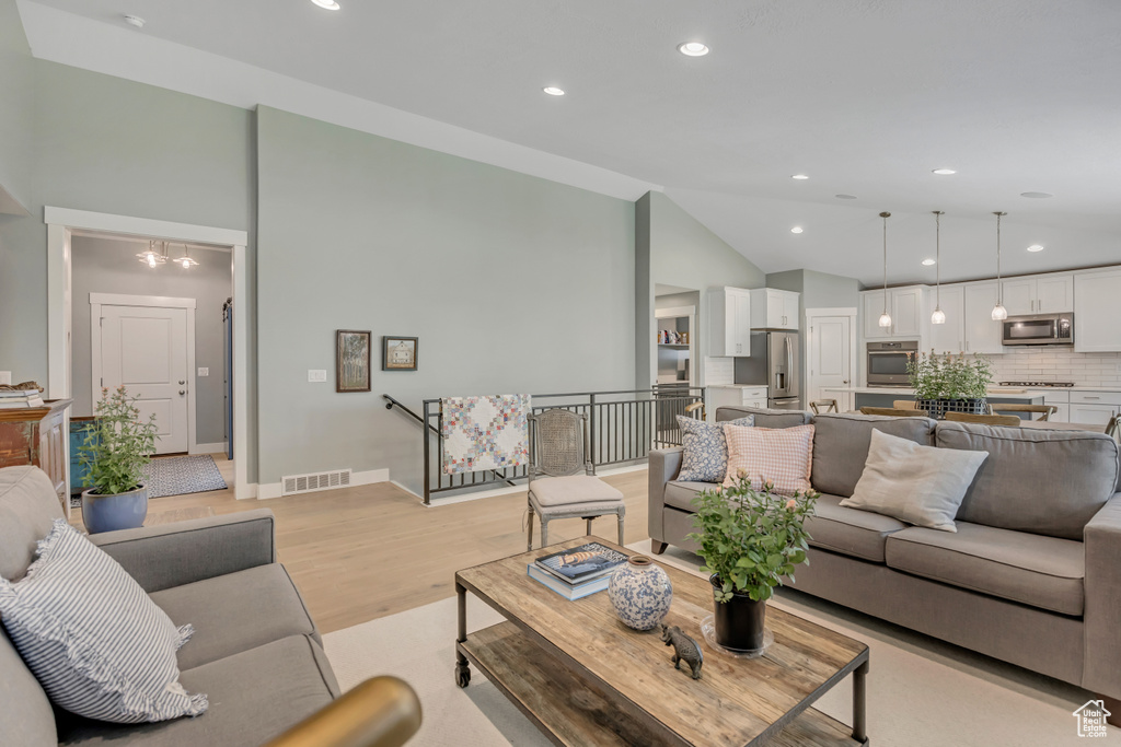 Living area featuring recessed lighting, light wood-type flooring, and high vaulted ceiling
