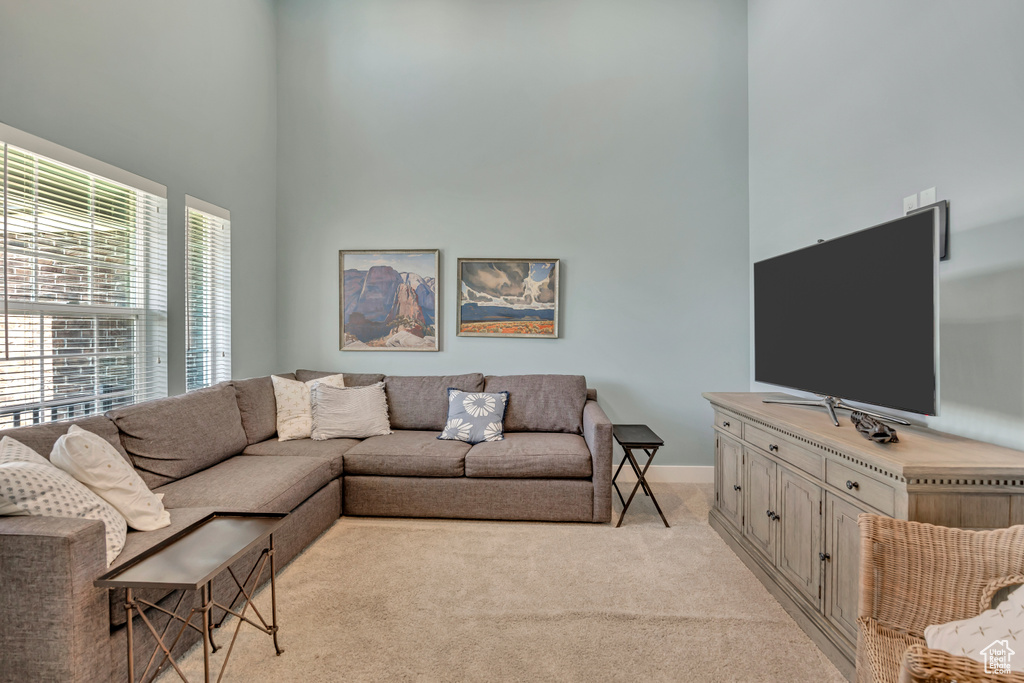 Living room with a towering ceiling and light carpet