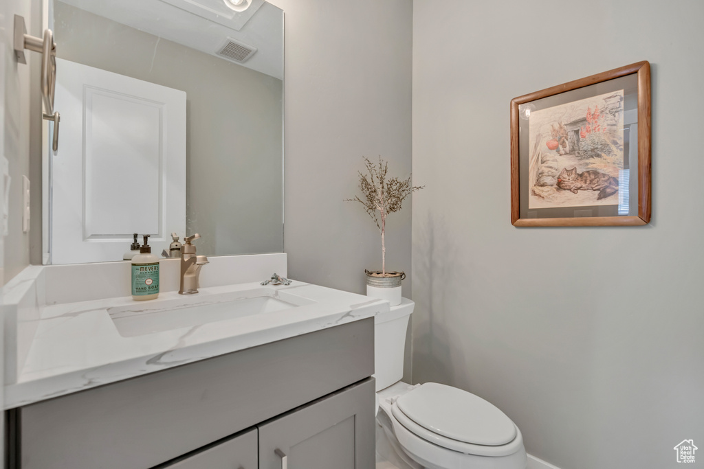 Half bathroom with vanity and toilet