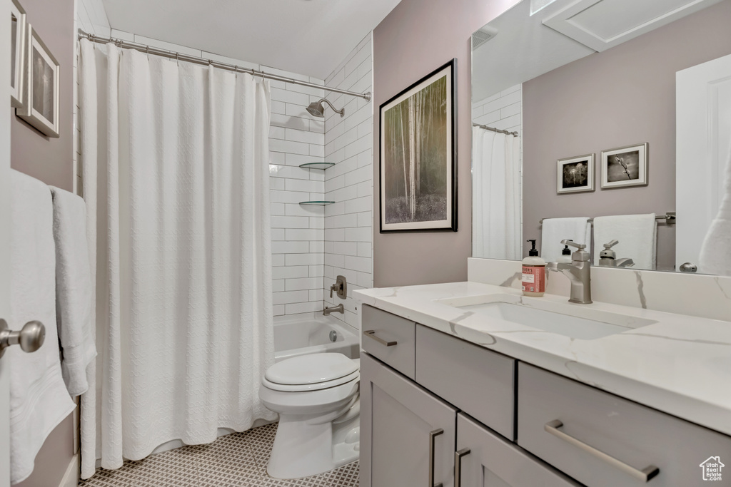 Bathroom with vanity, shower / bath combo, and tile patterned flooring