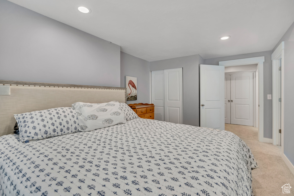 Bedroom featuring light colored carpet, recessed lighting, and a closet