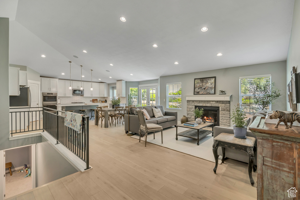 Living area with recessed lighting, light wood-style flooring, and a fireplace