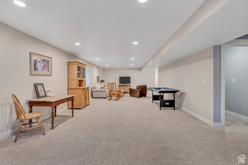 Living area with light carpet and recessed lighting