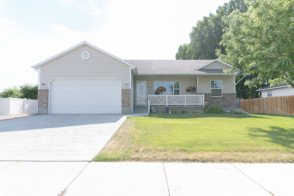 Ranch-style house with brick siding, a garage, concrete driveway, and covered porch