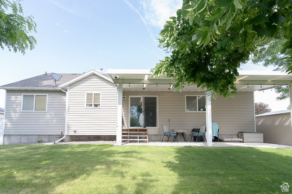 Rear view of house with a lawn and a patio area