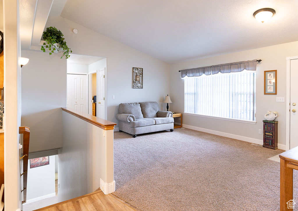 Living room featuring carpet and lofted ceiling