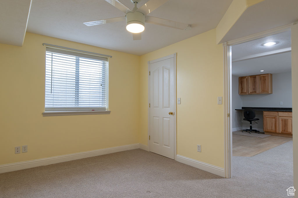 Unfurnished bedroom featuring light carpet, a desk, recessed lighting, and ceiling fan