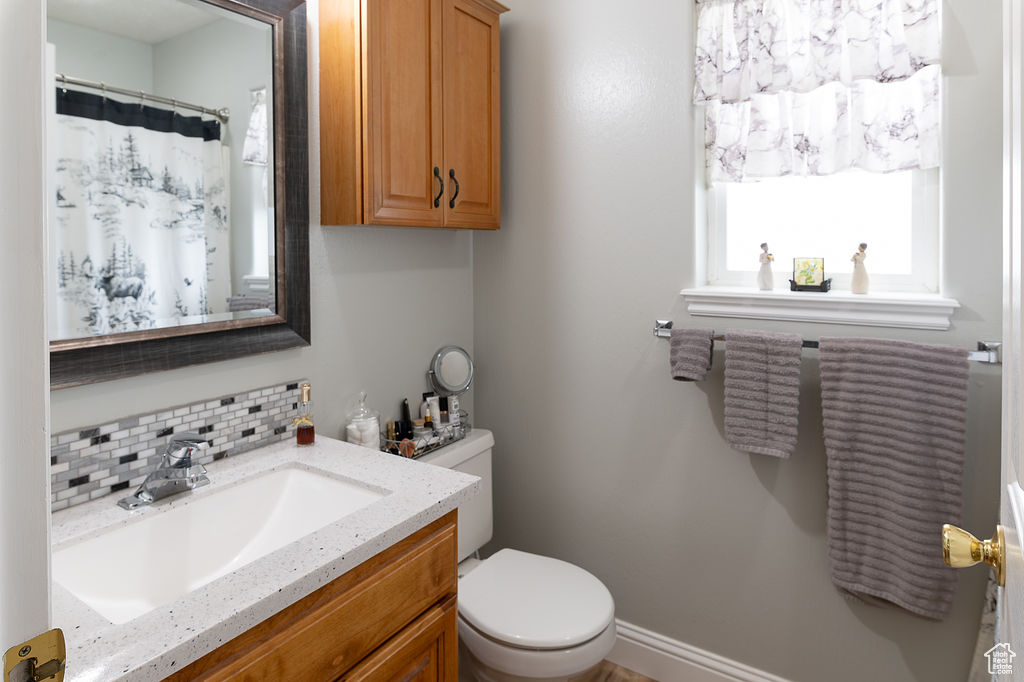 Bathroom with vanity and tasteful backsplash