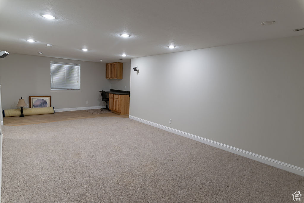Below grade area featuring recessed lighting and light colored carpet