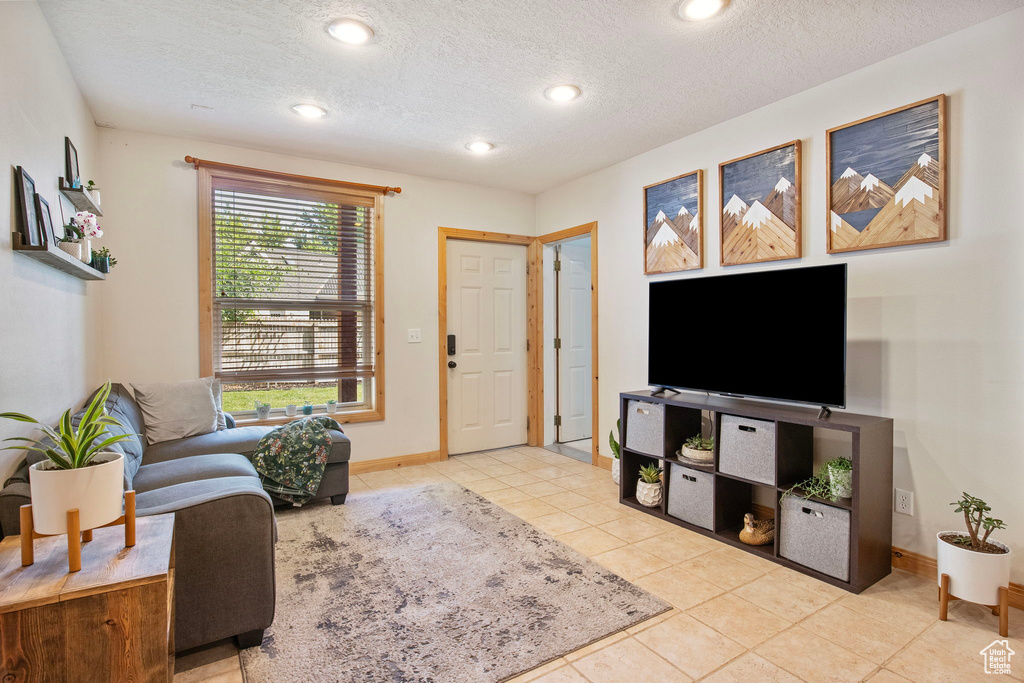 Living room featuring light tile patterned floors, a textured ceiling, and recessed lighting