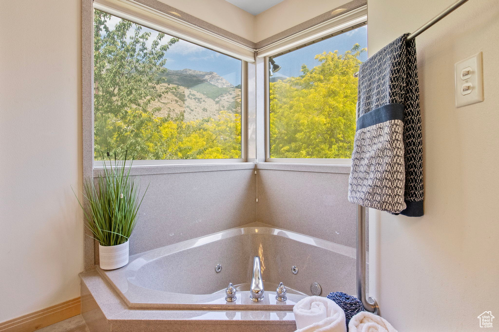 Full bathroom featuring a tub with jets and healthy amount of natural light