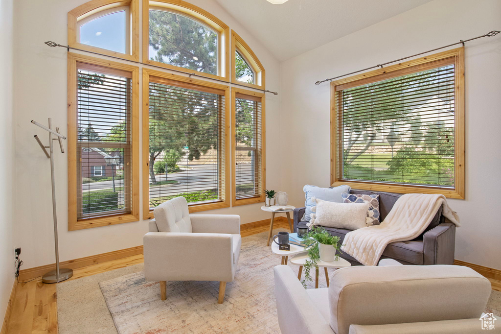 Living area featuring vaulted ceiling, plenty of natural light, and wood finished floors