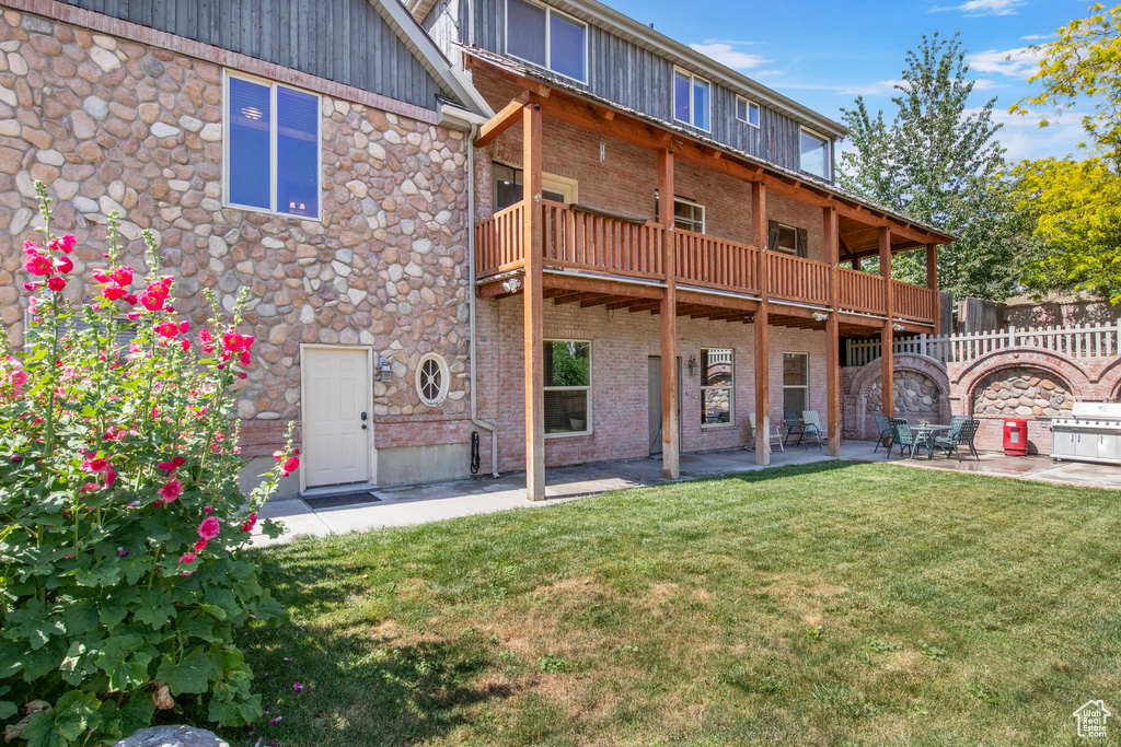 Back of property featuring a patio area, brick siding, and board and batten siding