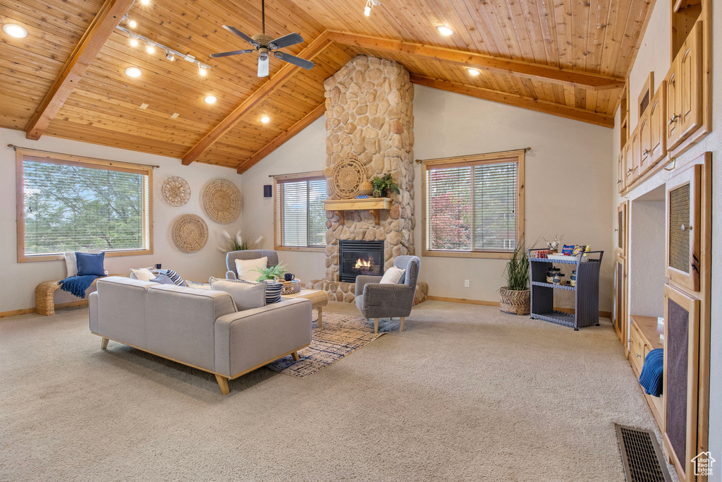 Carpeted living room with a wooden ceiling with exposed beams, a fireplace, a ceiling fan, high vaulted ceiling, and track lighting