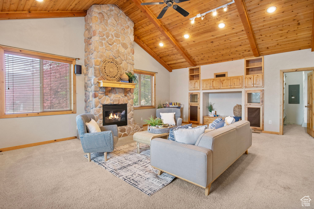 Living room with light carpet, a wooden ceiling with exposed beams, a ceiling fan, a fireplace, and electric panel