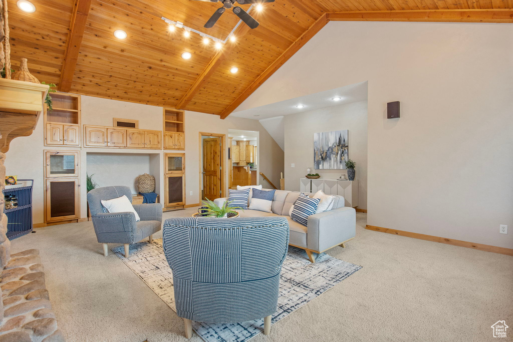 Living room with wood ceiling, light colored carpet, a ceiling fan, and high vaulted ceiling