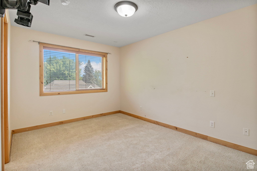 Carpeted empty room featuring baseboards