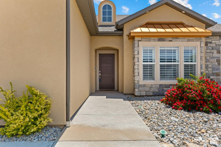 Entrance to property with stone siding and stucco siding