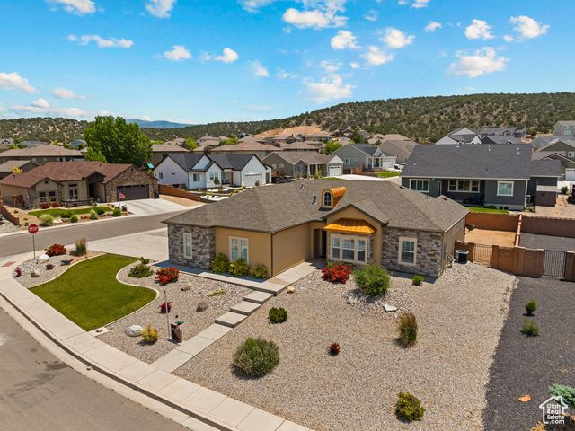 View of front facade with a residential view, a garage, and stone siding