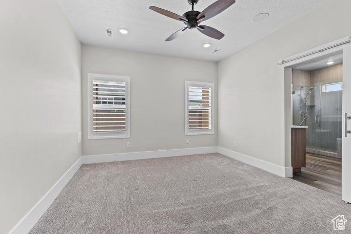 Empty room with healthy amount of natural light, carpet, ceiling fan, and recessed lighting