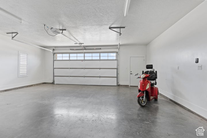Garage with baseboards and a garage door opener