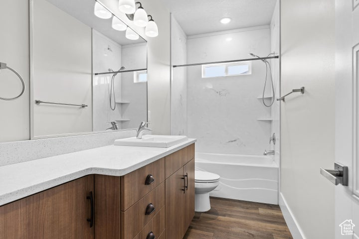 Full bathroom with wood finished floors, vanity, and bathing tub / shower combination