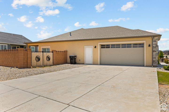 View of front of property featuring driveway, a garage, and stucco siding