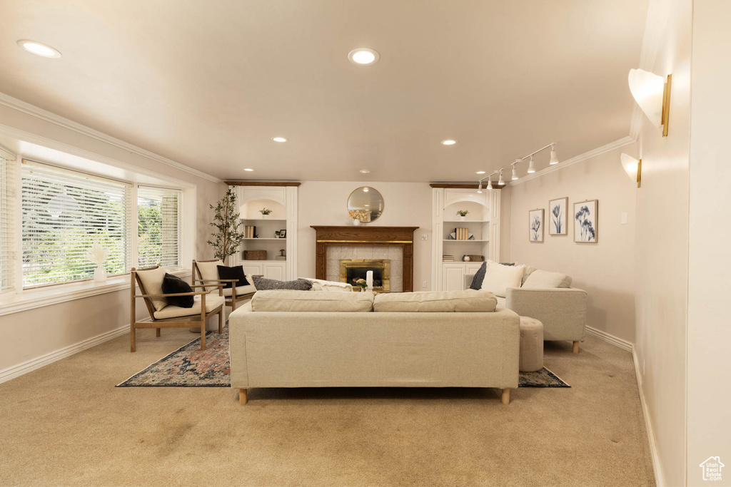 Living area with light colored carpet, ornamental molding, recessed lighting, a fireplace, and built in shelves